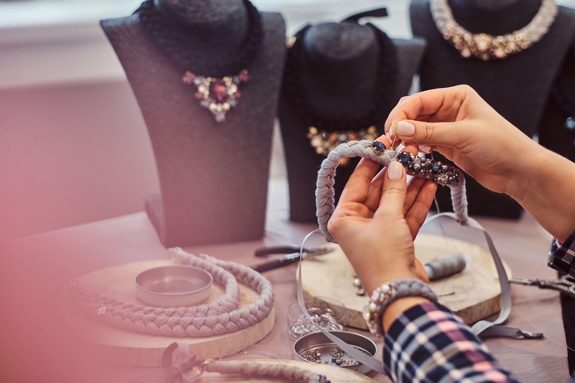 Le mani di un'artigiana Onilli Bijoux mentre monta un bracciale